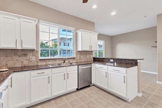 kitchen with kitchen peninsula, backsplash, white cabinets, sink, and dishwasher