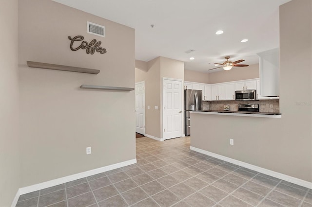 kitchen featuring ceiling fan, stainless steel appliances, kitchen peninsula, decorative backsplash, and white cabinets