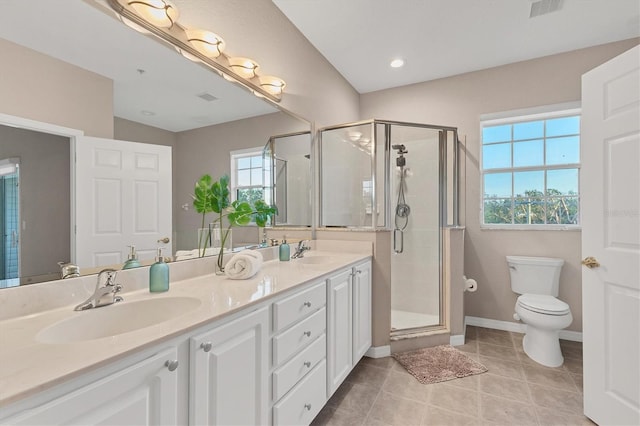 bathroom with tile patterned floors, vanity, a shower with shower door, and toilet