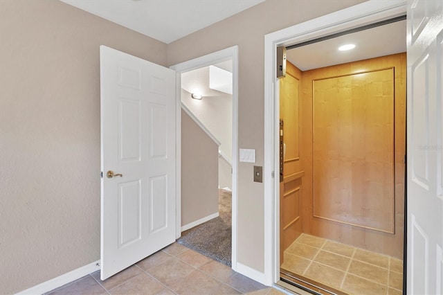 interior space with tile patterned flooring and elevator