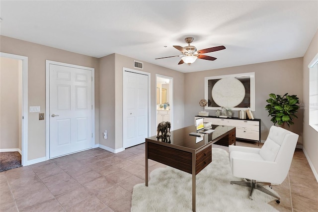 tiled office space featuring ceiling fan