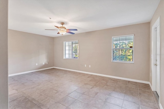 spare room featuring light tile patterned floors, ceiling fan, and a healthy amount of sunlight