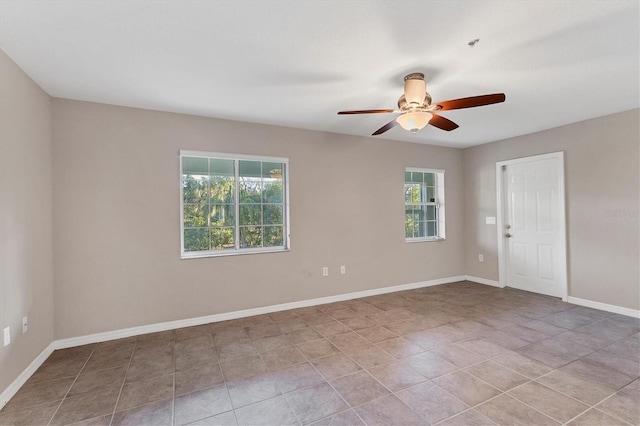 spare room with ceiling fan, light tile patterned floors, and plenty of natural light