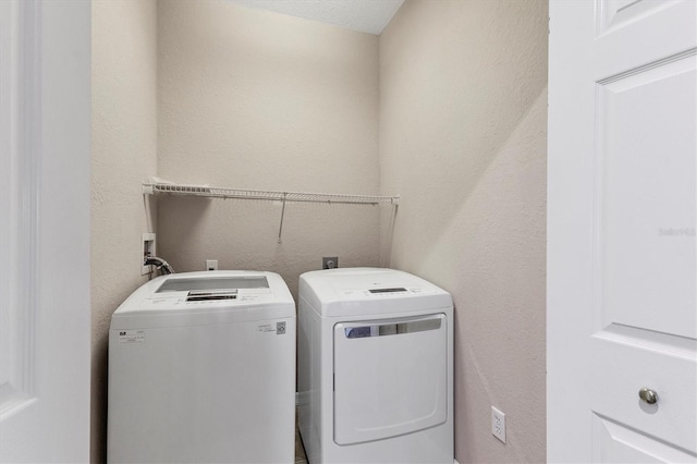 laundry room featuring independent washer and dryer and a textured ceiling