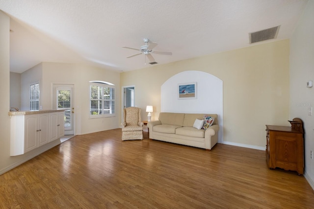 unfurnished living room featuring a textured ceiling, light wood-type flooring, and ceiling fan