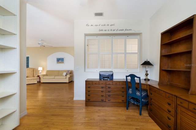 office area with built in desk, ceiling fan, and light hardwood / wood-style flooring