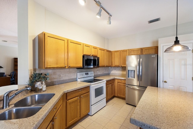 kitchen with light stone counters, sink, backsplash, pendant lighting, and appliances with stainless steel finishes