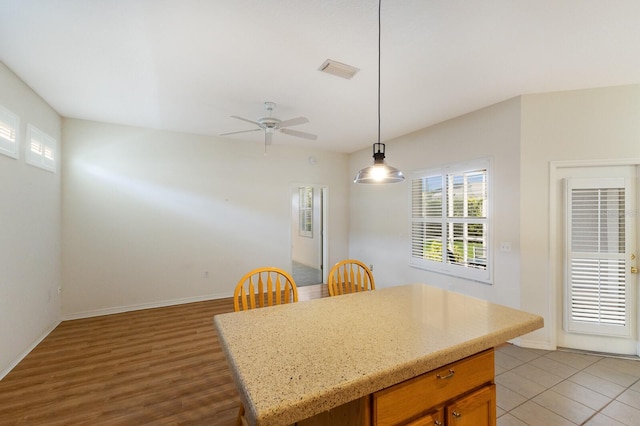 kitchen featuring light hardwood / wood-style floors, decorative light fixtures, ceiling fan, and a kitchen island