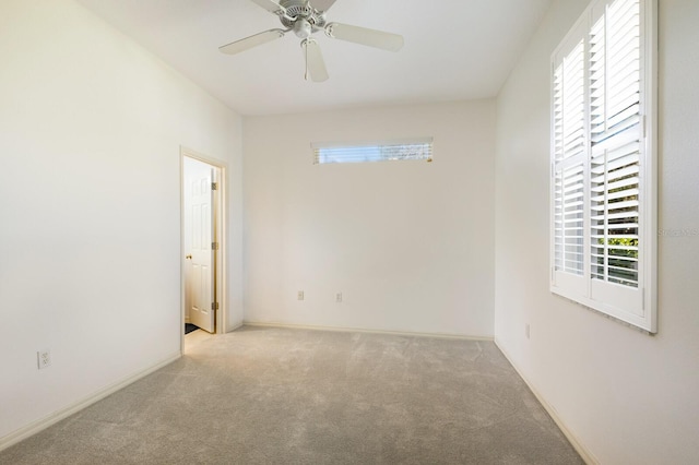 empty room featuring ceiling fan and light carpet