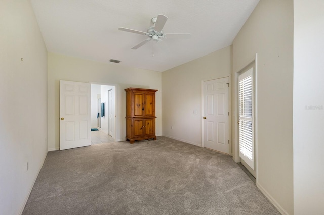 unfurnished bedroom featuring multiple windows, light colored carpet, and ceiling fan