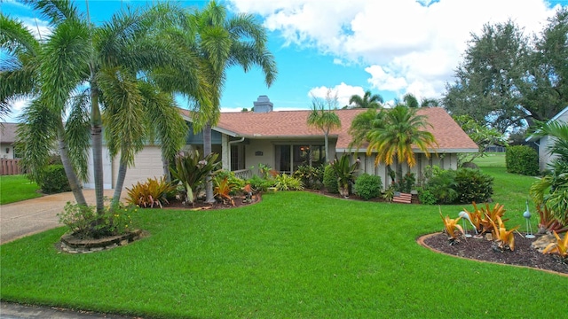 single story home featuring a front lawn and a garage