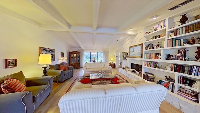 living area featuring vaulted ceiling with beams and light hardwood / wood-style floors