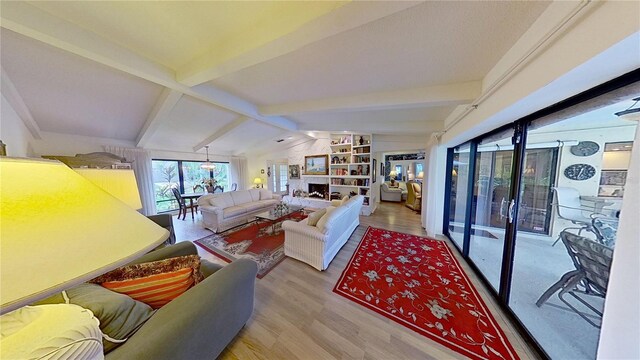 living room featuring lofted ceiling with beams and light hardwood / wood-style flooring