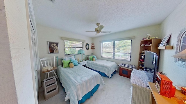 bedroom with ceiling fan, a closet, carpet, and a textured ceiling