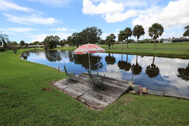 view of dock with a water view and a yard