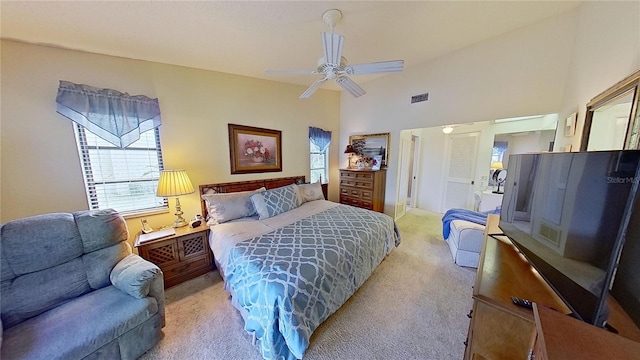 carpeted bedroom with a high ceiling and ceiling fan