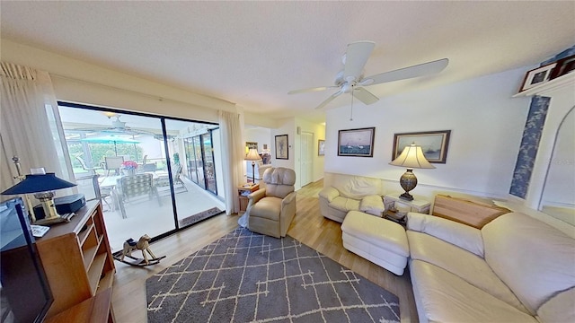 living room featuring a textured ceiling, ceiling fan, and dark wood-type flooring