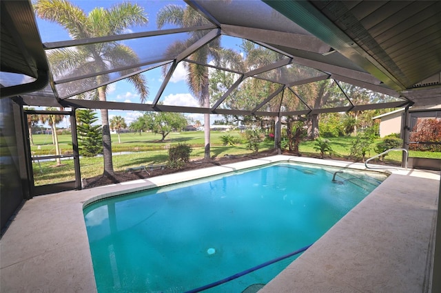 view of swimming pool with a yard, a patio, and a lanai