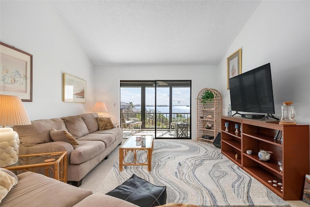 carpeted living room with a textured ceiling and vaulted ceiling