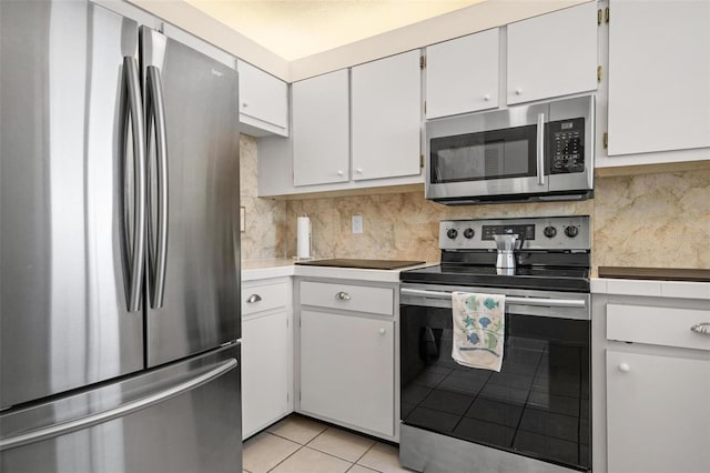 kitchen featuring tasteful backsplash, appliances with stainless steel finishes, light tile patterned floors, and white cabinets