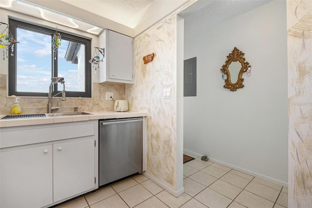 kitchen with sink, white cabinetry, backsplash, light tile patterned flooring, and stainless steel dishwasher