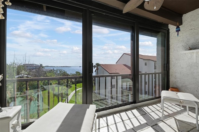 balcony with a water view and ceiling fan