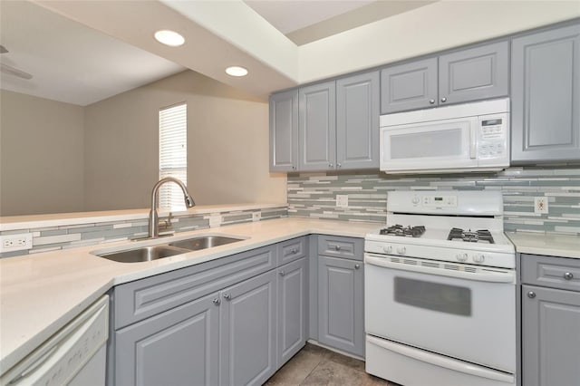 10550 Old Grove Cir, Bradenton, FL 34212 - kitchen with white appliances, gray cabinetry, a sink, backsplash, and light countertops