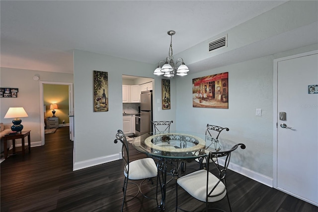 dining area featuring dark hardwood / wood-style flooring and an inviting chandelier