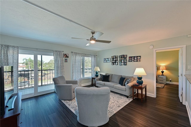 living room with ceiling fan, dark hardwood / wood-style flooring, and a textured ceiling