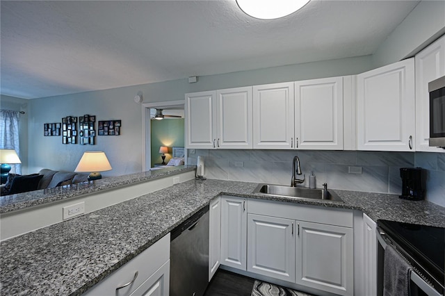 kitchen with backsplash, white cabinetry, sink, and stainless steel appliances