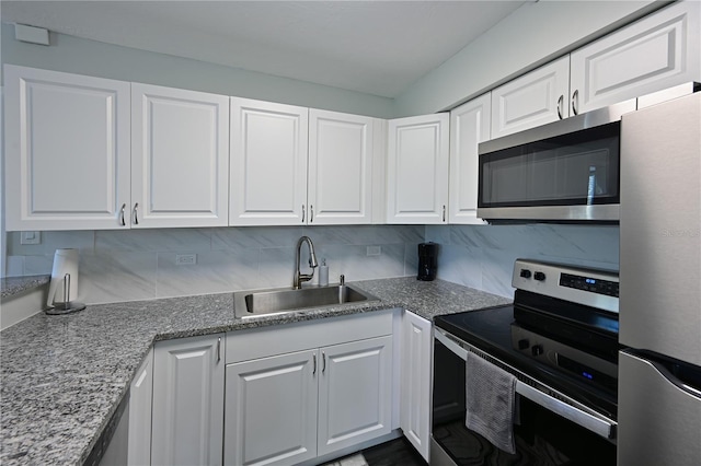 kitchen featuring white cabinets, stainless steel appliances, tasteful backsplash, and sink