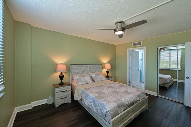 bedroom with a textured ceiling, a closet, ceiling fan, and dark wood-type flooring