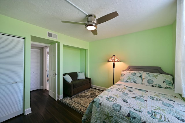 bedroom featuring ceiling fan, a closet, dark wood-type flooring, and a textured ceiling