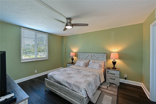 bedroom with a textured ceiling, ceiling fan, and dark wood-type flooring