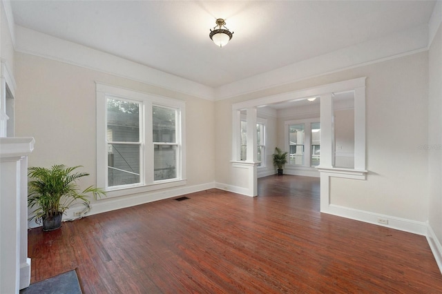 unfurnished living room featuring dark hardwood / wood-style floors and crown molding