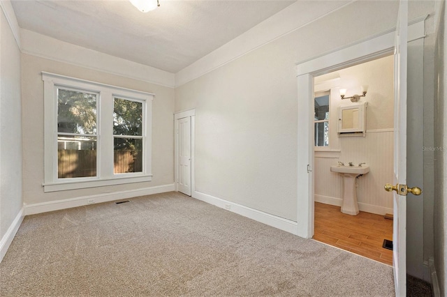 unfurnished bedroom featuring carpet flooring and connected bathroom