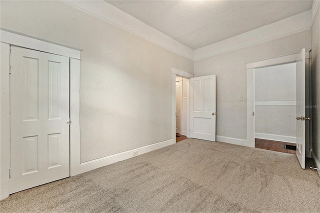 unfurnished bedroom with carpet flooring and a closet