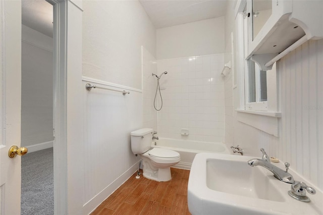 full bathroom featuring tiled shower / bath combo, hardwood / wood-style flooring, toilet, and sink