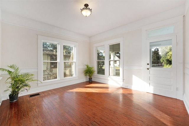 unfurnished room featuring visible vents and wood finished floors