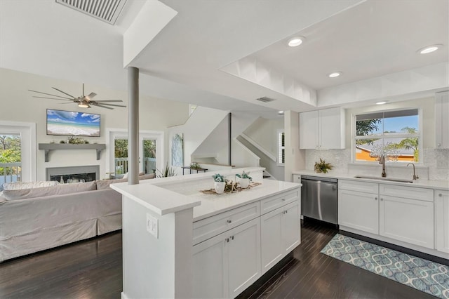 kitchen featuring white cabinetry, dishwasher, a center island, sink, and tasteful backsplash