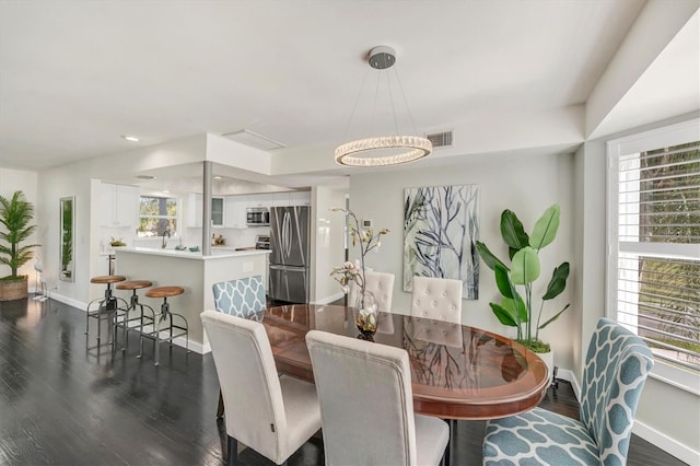 dining space with a wealth of natural light and dark wood-type flooring