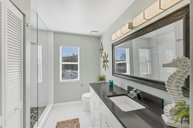 bathroom featuring tile patterned flooring, vanity, toilet, and a tile shower