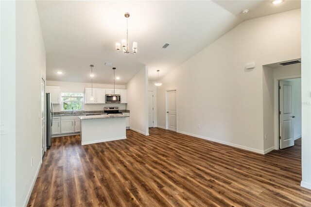 kitchen with stainless steel appliances, a kitchen island, white cabinetry, dark hardwood / wood-style floors, and lofted ceiling