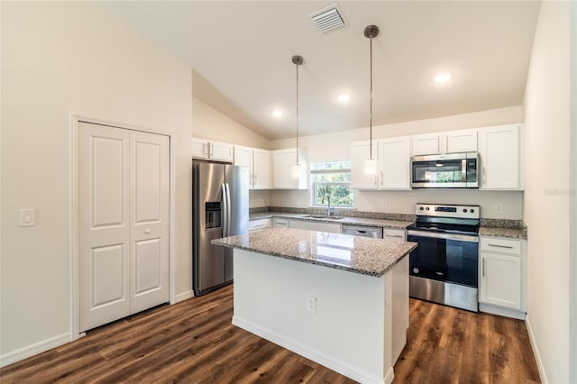 kitchen with stainless steel appliances, a kitchen island, white cabinetry, sink, and lofted ceiling