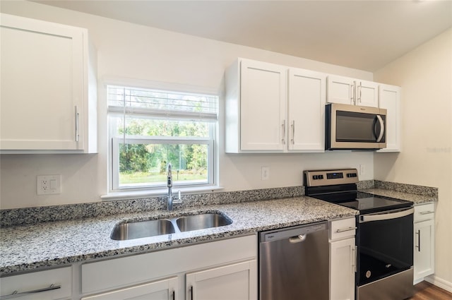 kitchen with white cabinetry, wood-type flooring, sink, and stainless steel appliances