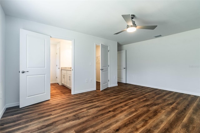 unfurnished bedroom with dark wood-type flooring, ceiling fan, and connected bathroom