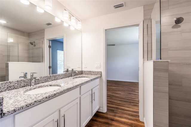 bathroom featuring tiled shower, hardwood / wood-style flooring, and vanity