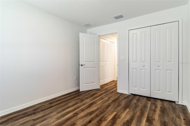 unfurnished bedroom featuring dark wood-type flooring and a closet