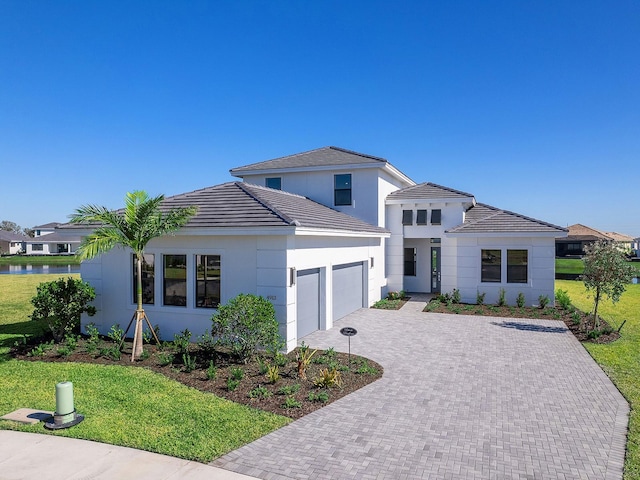 view of front of property with a garage and a front lawn