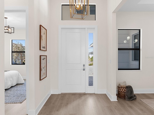 entrance foyer featuring light hardwood / wood-style floors and a notable chandelier